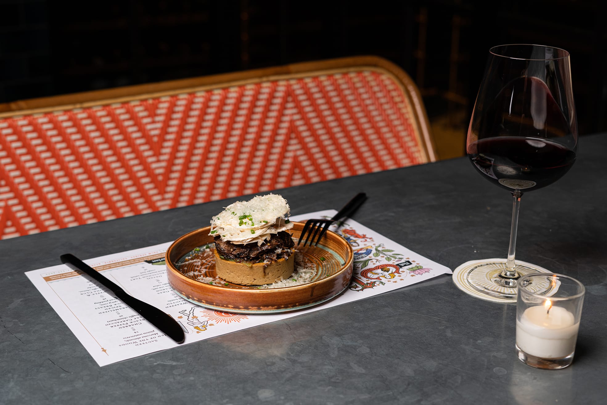 dish with a glass of wine on candlelit table